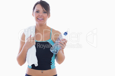 Portrait of woman in sportswear holding towel around neck and wa