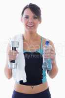 Portrait of woman holding dumbbell and water bottle