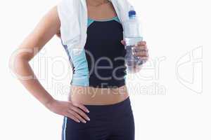 Sporty woman with towel around neck and water bottle