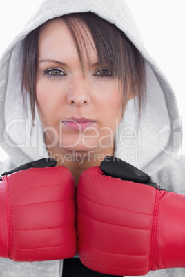 Close-up portrait of young woman wearing boxing gloves