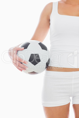 Midsection of fit woman in sportswear with football