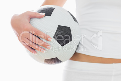 Midsection of fit woman in sportswear with football