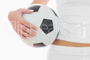 Midsection of fit woman in sportswear with football