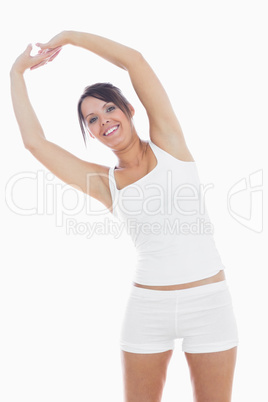 Portrait of smiling woman in sportswear holding hands up togethe