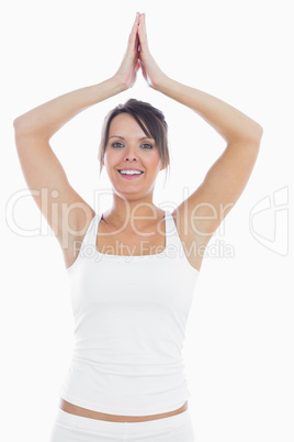 Portrait of woman in sportswear joining hands over head