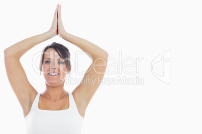 Portrait of smiling woman joining hands over head