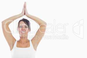 Portrait of smiling woman joining hands over head