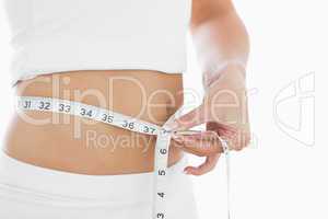 Close-up midsection of woman measuring waist