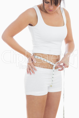 Young woman measuring waist