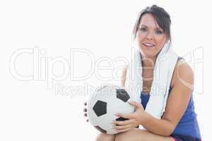 Portrait of happy woman in sportswear holding football