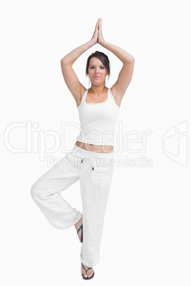 Portrait of woman in sportswear doing the tree pose