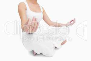 Midsection of young woman sitting in lotus position