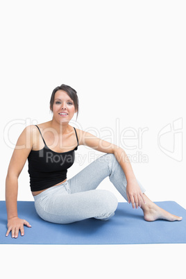 Portrait of woman in sportswear sitting on yoga mat