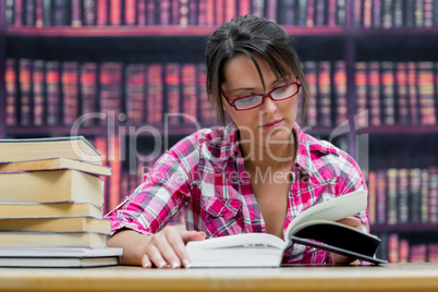 College student reading a book in library