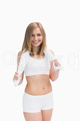 Portrait of happy woman in sportswear holding towel around neck