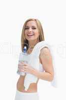 Portrait of happy woman with towel holding water bottle