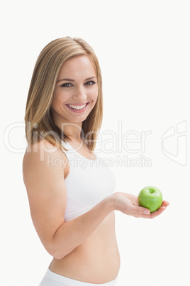 Portrait of happy young woman holding green apple