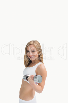 Portrait of young woman exercising with dumbbell