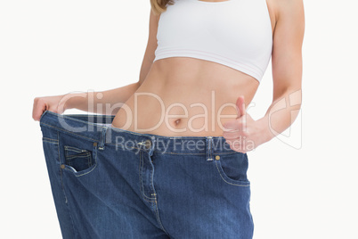 Midsection of woman wearing old pants after losing weight and ge