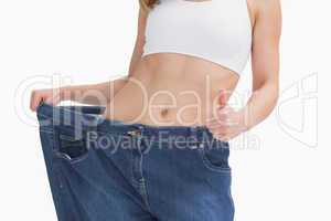 Midsection of woman wearing old pants after losing weight and ge