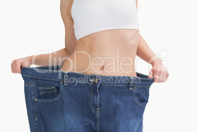 Midsection of female wearing old pants after losing weight