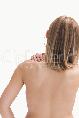 Rear view of topless young woman with shoulder pain