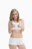 Portrait of happy woman in sportswear gesturing double thumbs up
