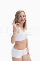 Portrait of happy woman in sportswear gesturing okay sign