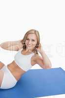 Portrait of happy young woman doing sit-ups on exercise mat