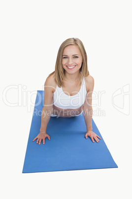 Portrait of happy woman doing push-ups on exercise mat