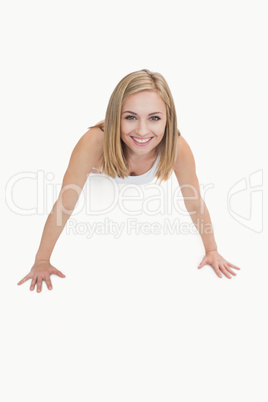 Portrait of happy young woman doing push-ups