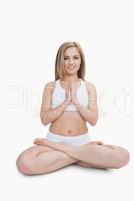 Portrait of young woman with crossed legs in praying position