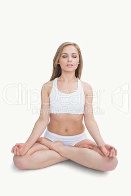 Woman sitting in lotus position with eyes closed