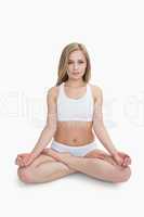 Portrait of young woman sitting in lotus position with eyes clos