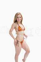 Portrait of happy young in bikini measuring waist