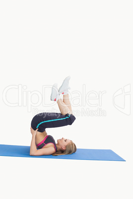 Side view of young woman in the shoulder stand position on yoga