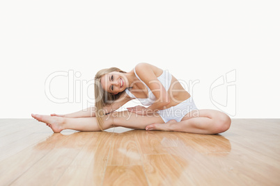 Portrait of young  woman stretching on hardwood floor