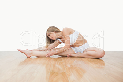 Young  woman in yoga pose on hardwood floor