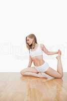 Young  woman doing physical exercise on hardwood floor