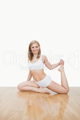 Portrait of young  woman doing physical exercise on hardwood flo