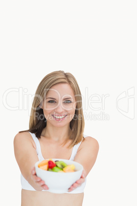 Portrait of woman offering you bowl of fruits