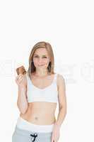 Portrait of young woman makes faces as holds cookie