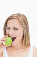 Close-up portrait of woman eating green apple