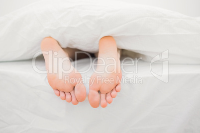 Woman's feet sticking out of blanket