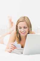 Woman doing online shopping through laptop and credit card in be
