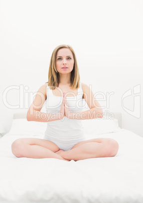 Woman in praying position on bed