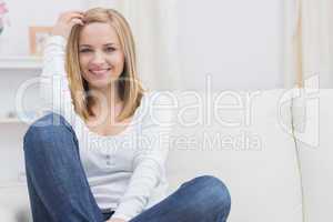 Casual happy young woman sitting on sofa