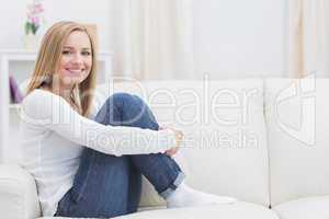 Portrait of casual happy woman sitting on sofa