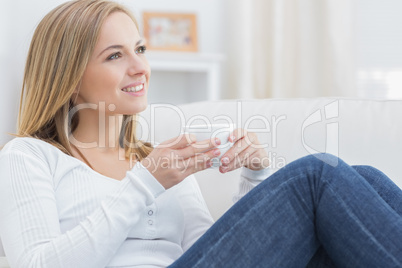 Woman with coffee cup day dreaming on couch