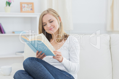 Happy woman reading storybook at home